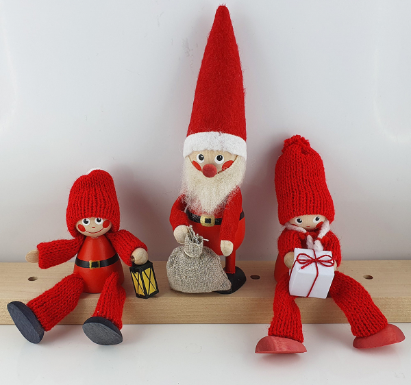 Nordischer Weihnachtsmann mit Sack, sitzende Wichtelfiguren, rot