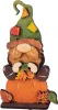Herbstwichtel auf Kürbis sitzend mit grüner Flickenmütze, h 10 cm, Steckfigur Sebastian Holzkränze, handbemalt